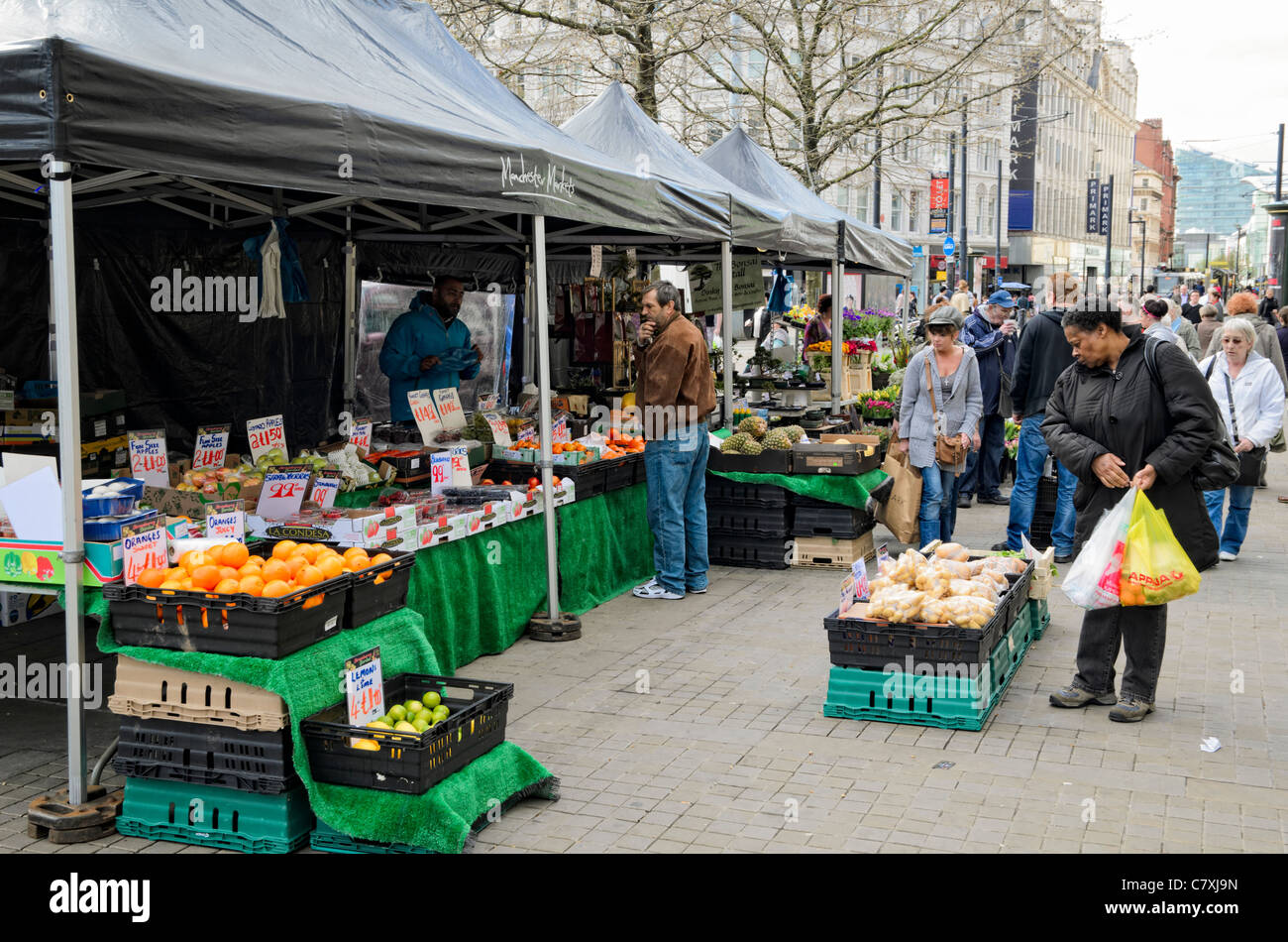 Outdoor market stalls in Piccadilly Gardens, Manchester, England. Customers represent the wide ethnic diversity of the city. Stock Photo
