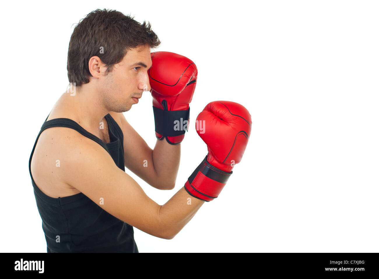 Profile of serious boxer man training with red boxing gloves isolated ...