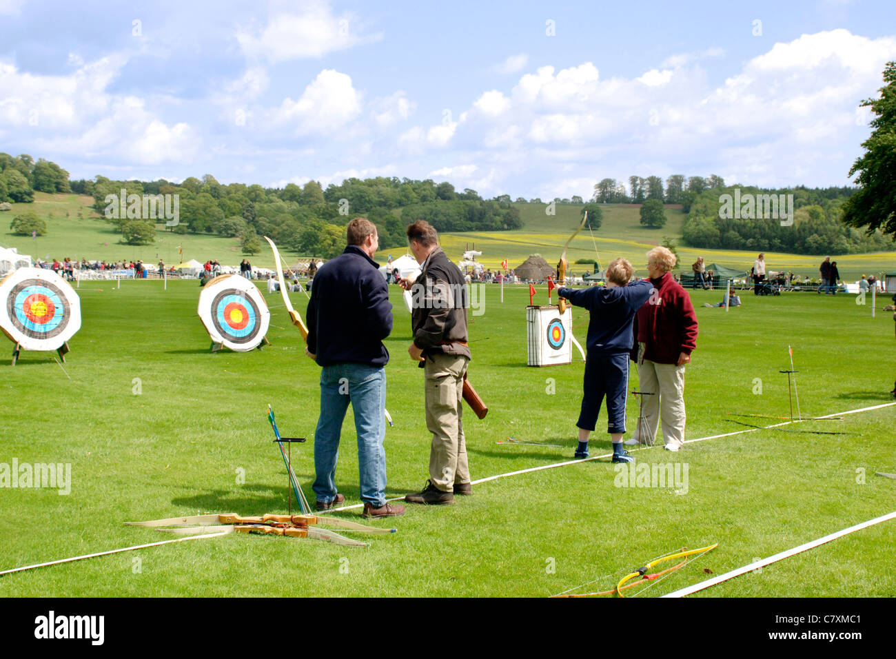 People having a go at Archery with trained instructors at an outdoor sports venue Stock Photo