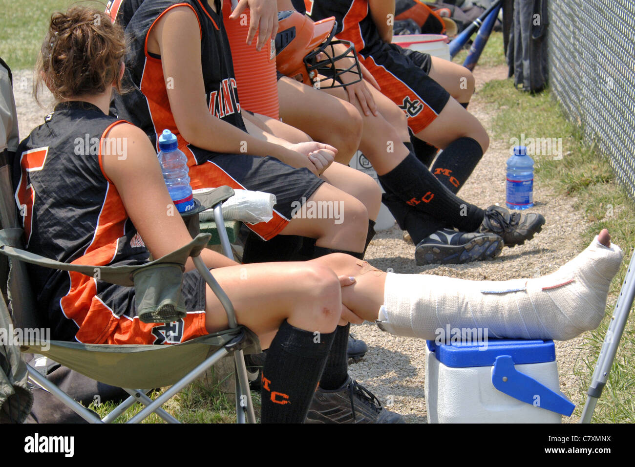 Injured female Softball player with her teammates. Stock Photo