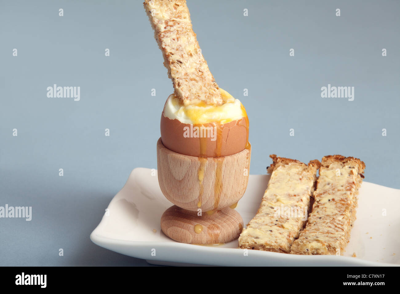 A toast 'soldier' dipped in a soft boiled egg Stock Photo
