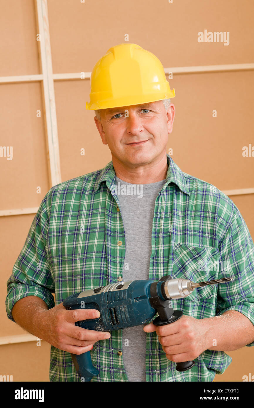 Mature handyman home improvement with hand drill portrait Stock Photo