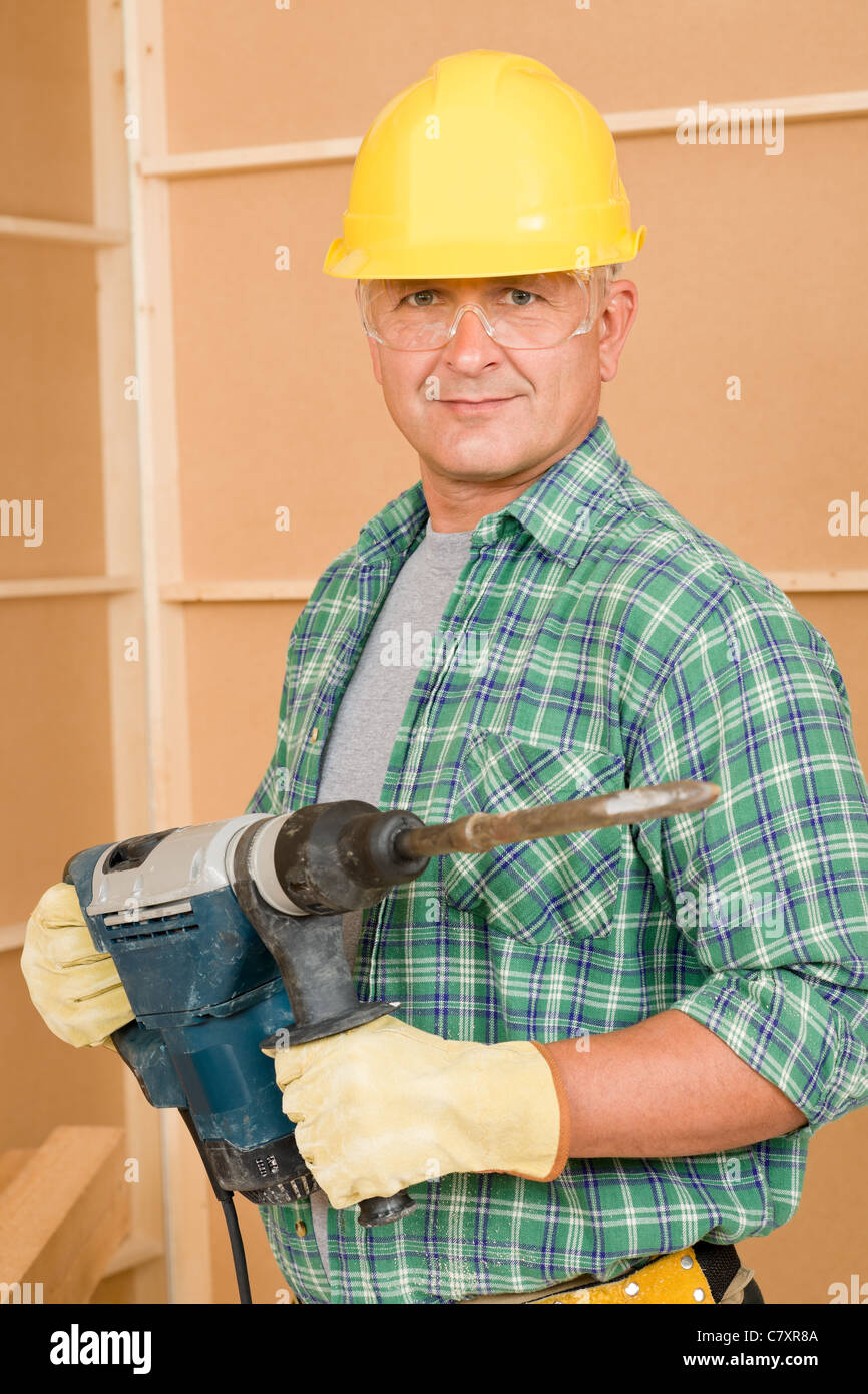 Handyman mature home improvement working with jackhammer diy Stock Photo