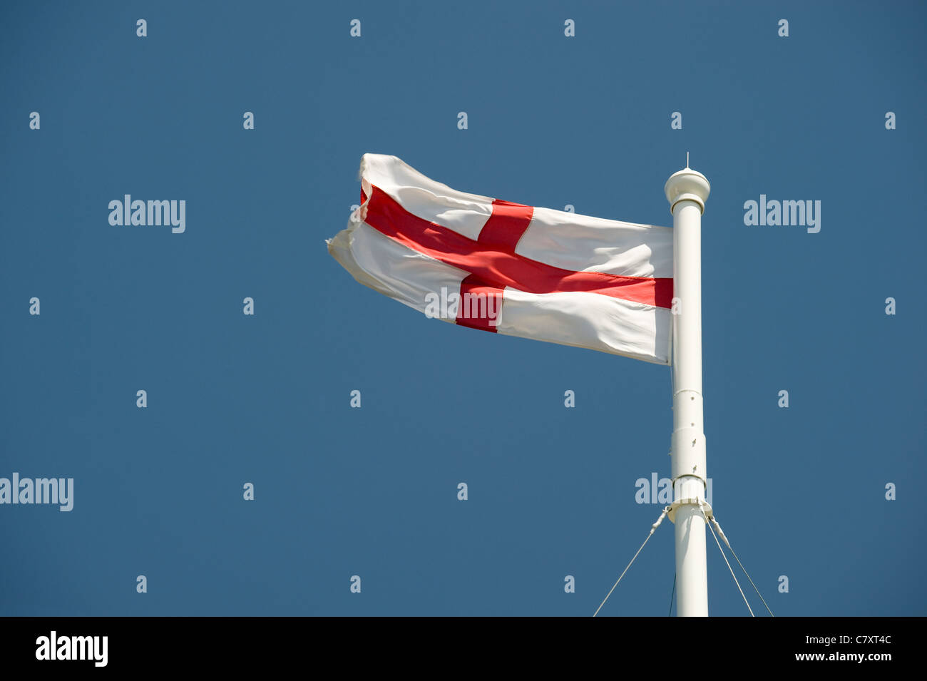 The Cross of St George flag flies from a church flagpole against a blue ...