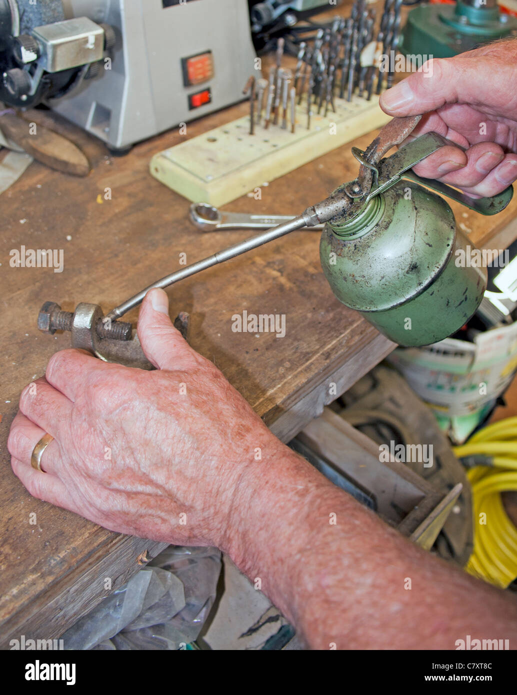 Engineer using a oil can to apply oil to a thread Stock Photo