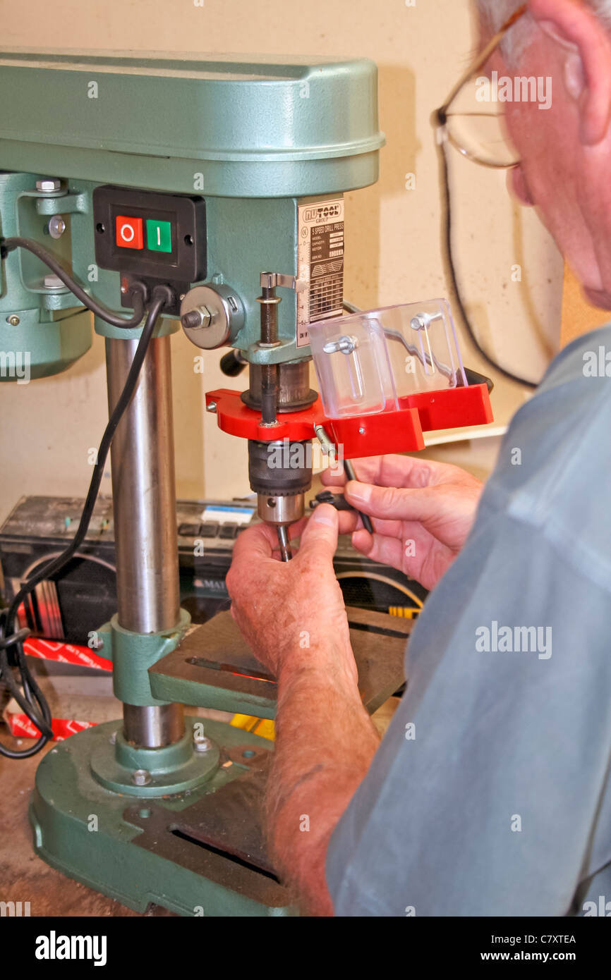 Engineer adjusting the chuck and drill bit on a electric pillar drill