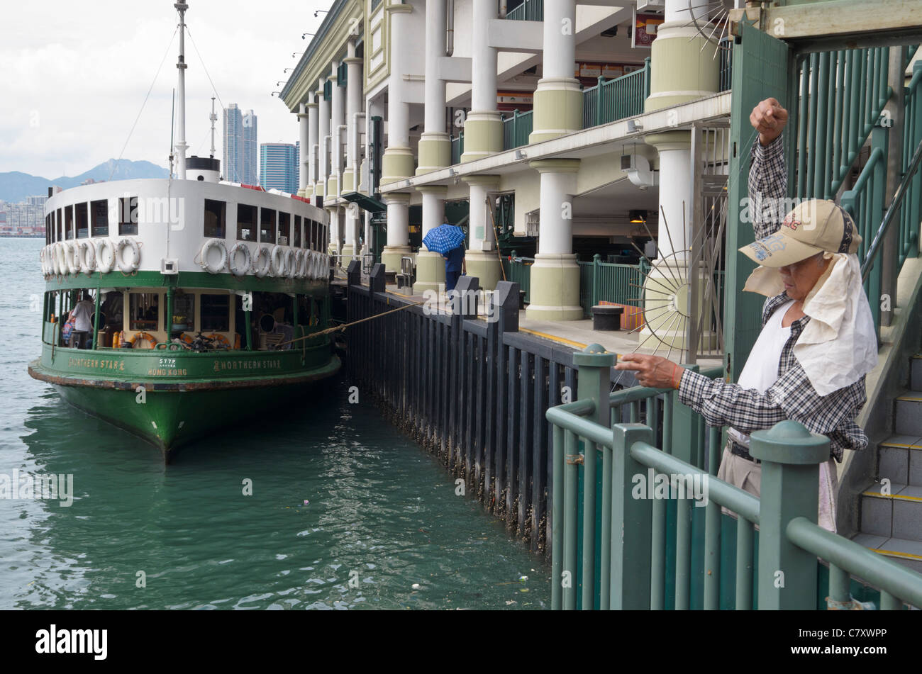 A man fishing in Victoria Harbour, next to the Star Ferry Pier, Central, Hong Kong Stock Photo