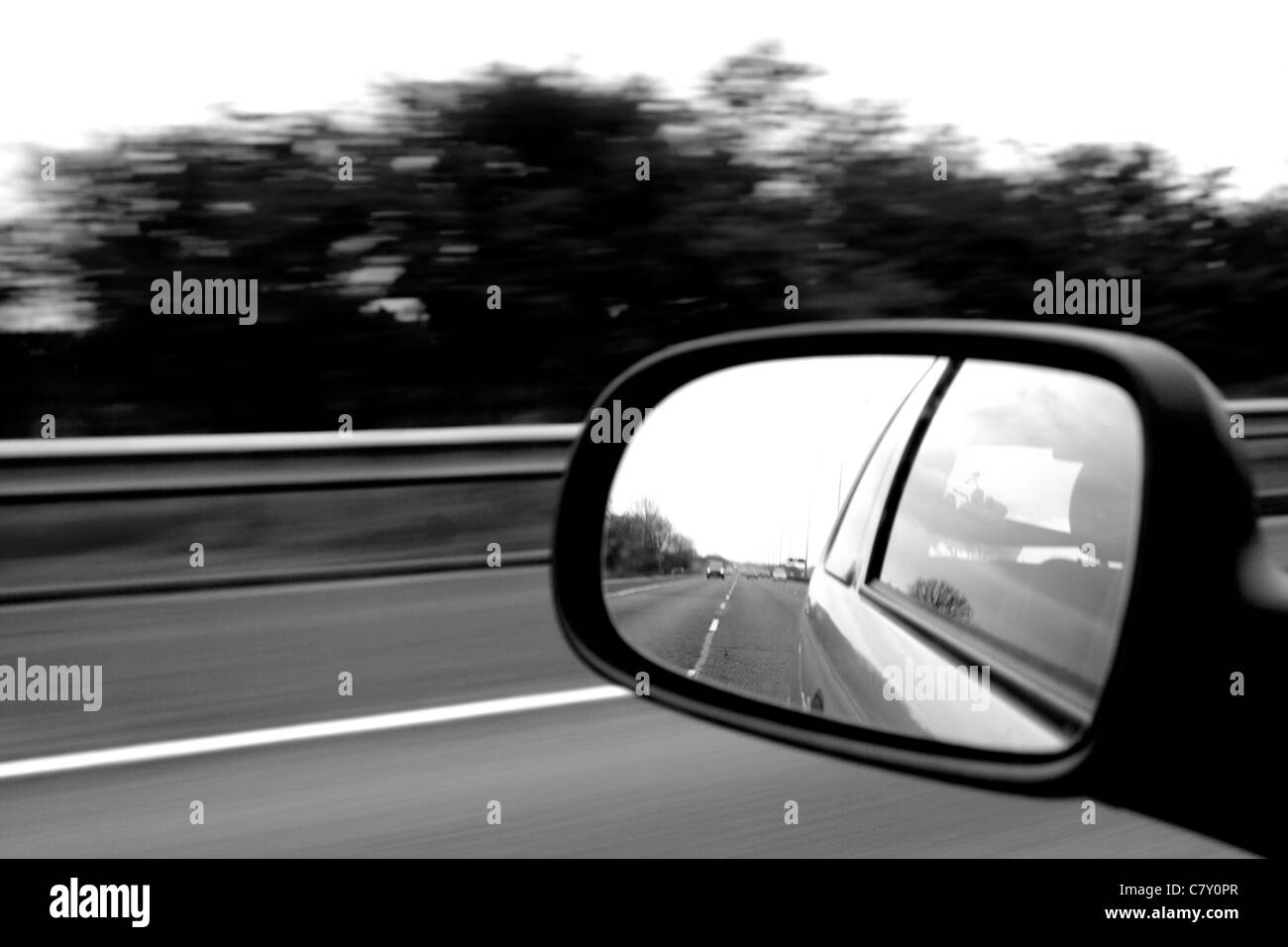 View from wing mirror of moving car on motorway, England, UK Stock Photo