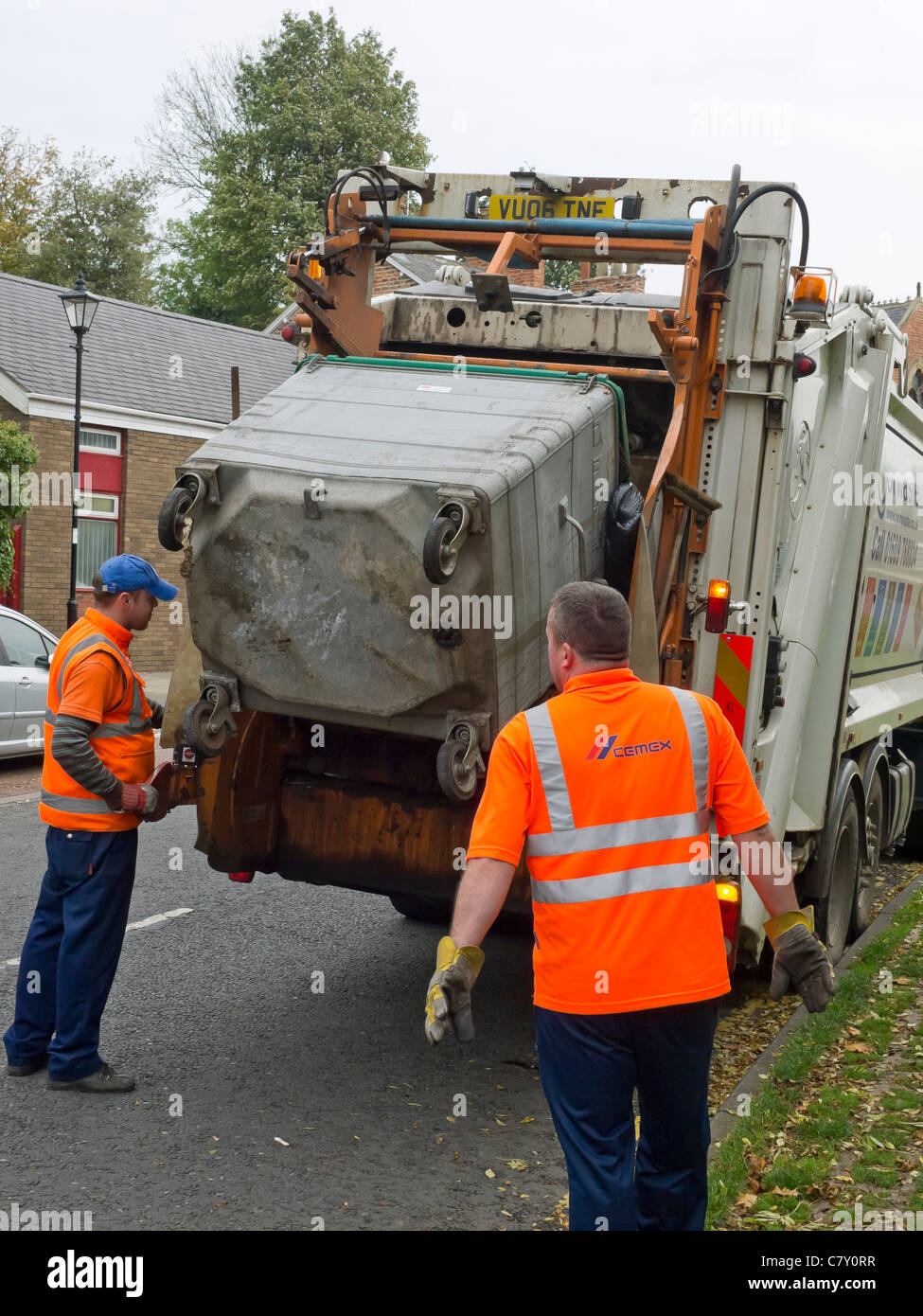 Waste Disposal Operatives tipping a commercial sized wheelie waste bin into a lorry Stock Photo
