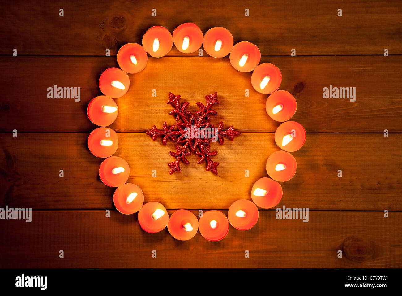 christmas candles circle over wood and red snowflake symbol Stock Photo