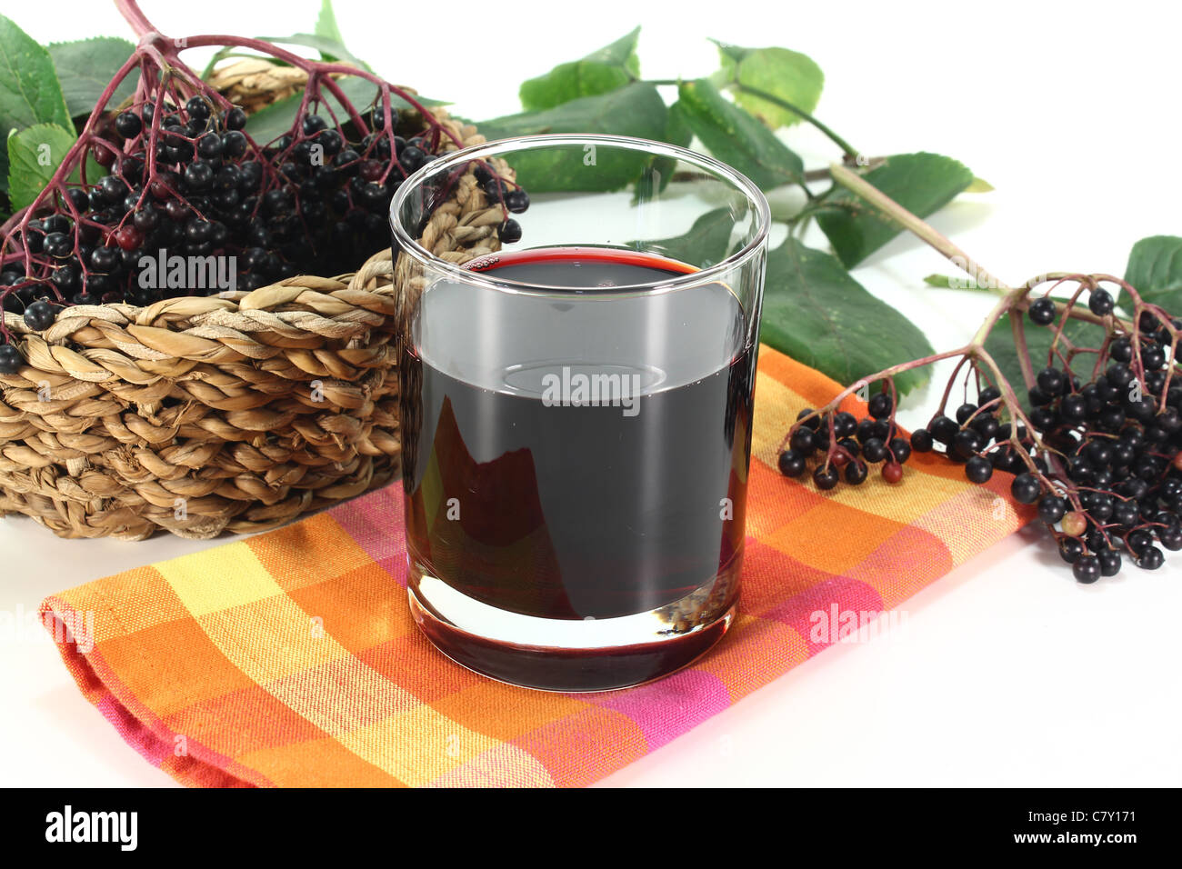 Elderberry juice with elder berries and leaves on a white background