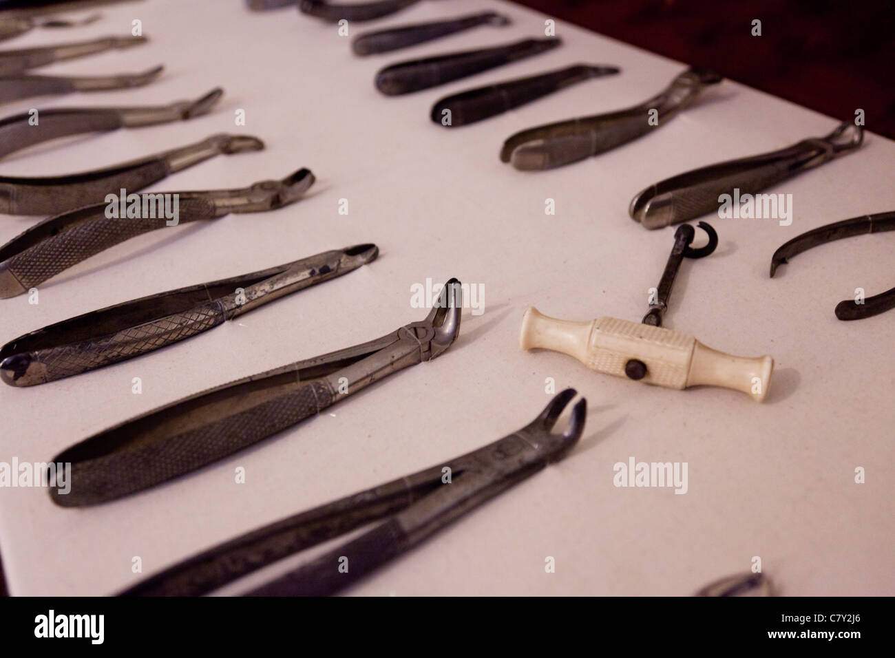 A selection of 19th Century dental instruments laid out on a white table cloth Stock Photo