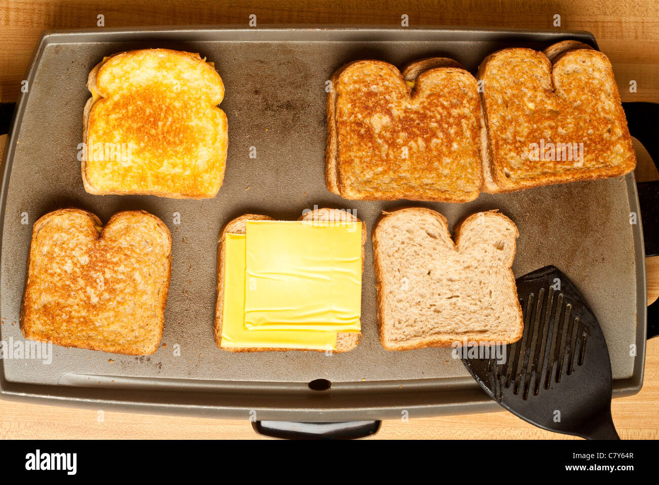 Five grilled cheese sandwiches cooking on a flat grill Stock Photo