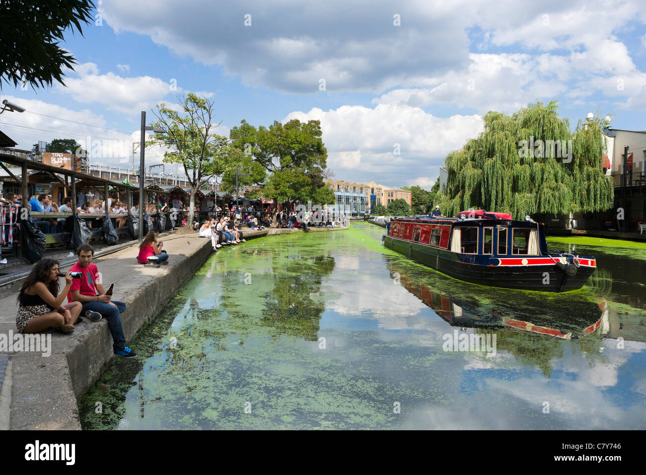 Young people sitting along the banks of the Regent's Canal at Camden Lock, North London, England, UK Stock Photo