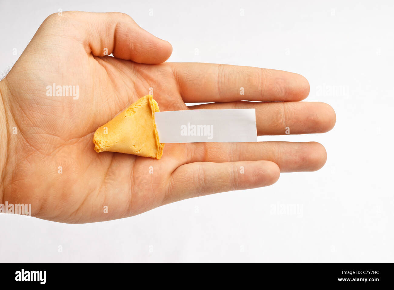Half of a fortune cookie in a hand with a blank fortune Stock Photo