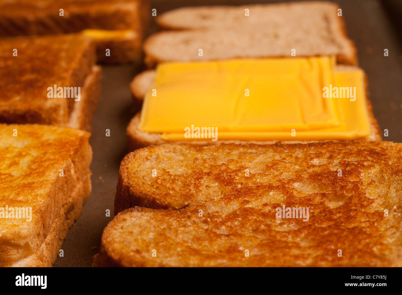 Golden brown grilled cheese being cooked on a flat grill Stock Photo