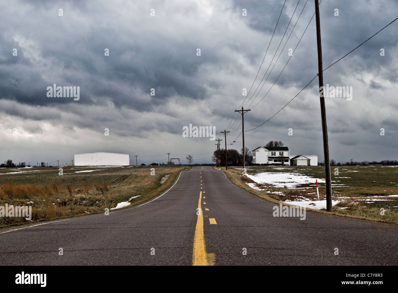 Long road leading into a storm in a rural environment Stock Photo