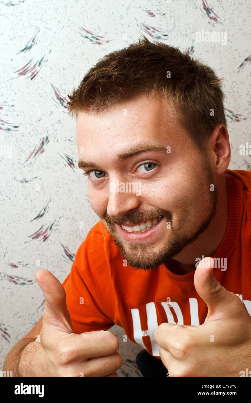 Young man with beard giving a thumbs up and smiling Stock Photo