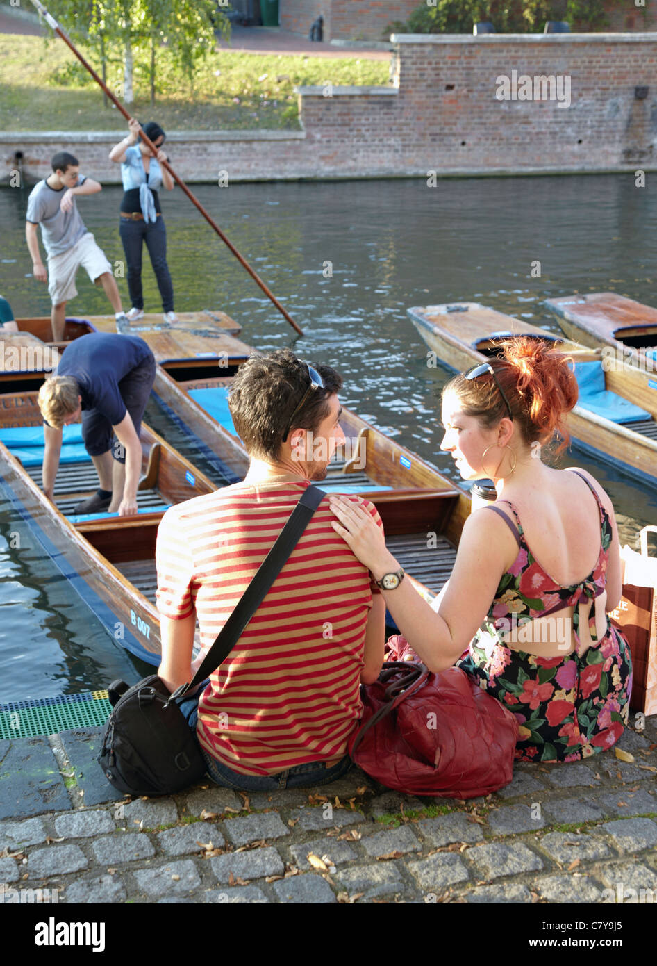Young Couple Watching Punting On The Cam River Cambridge UK Stock Photo