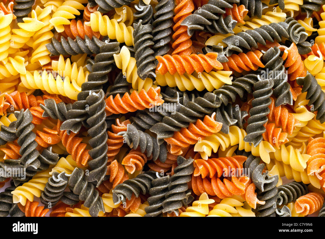 Tri-colored spiral pasta covering screen Stock Photo