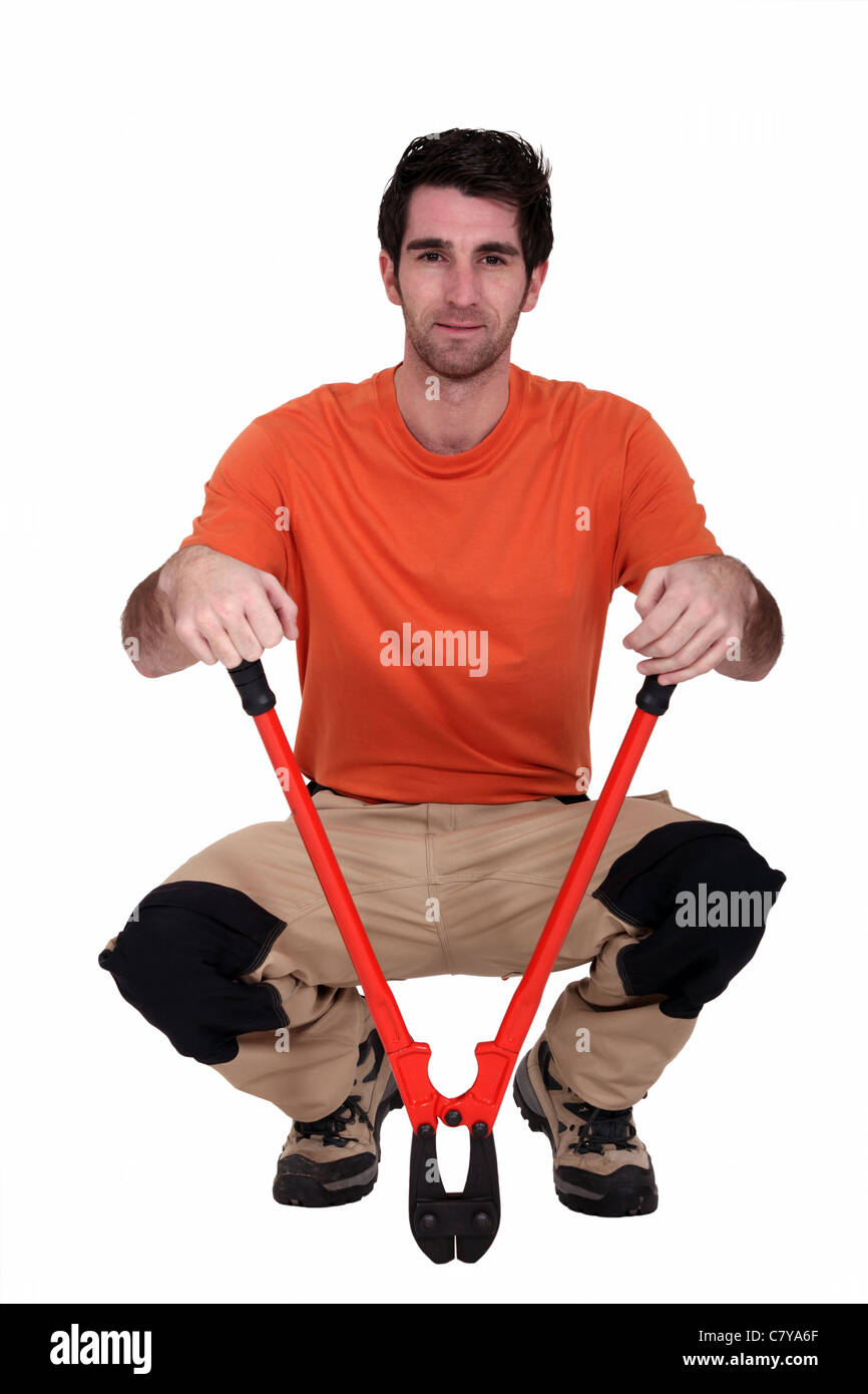 Man kneeling with bolt cutter Stock Photo Alamy