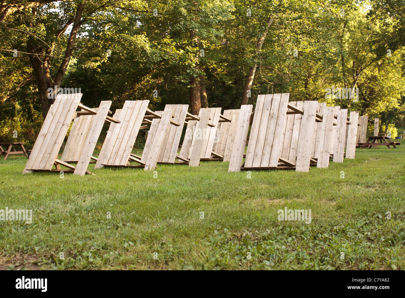 Rows of picnic tables standing up in a camping park setting Stock Photo
