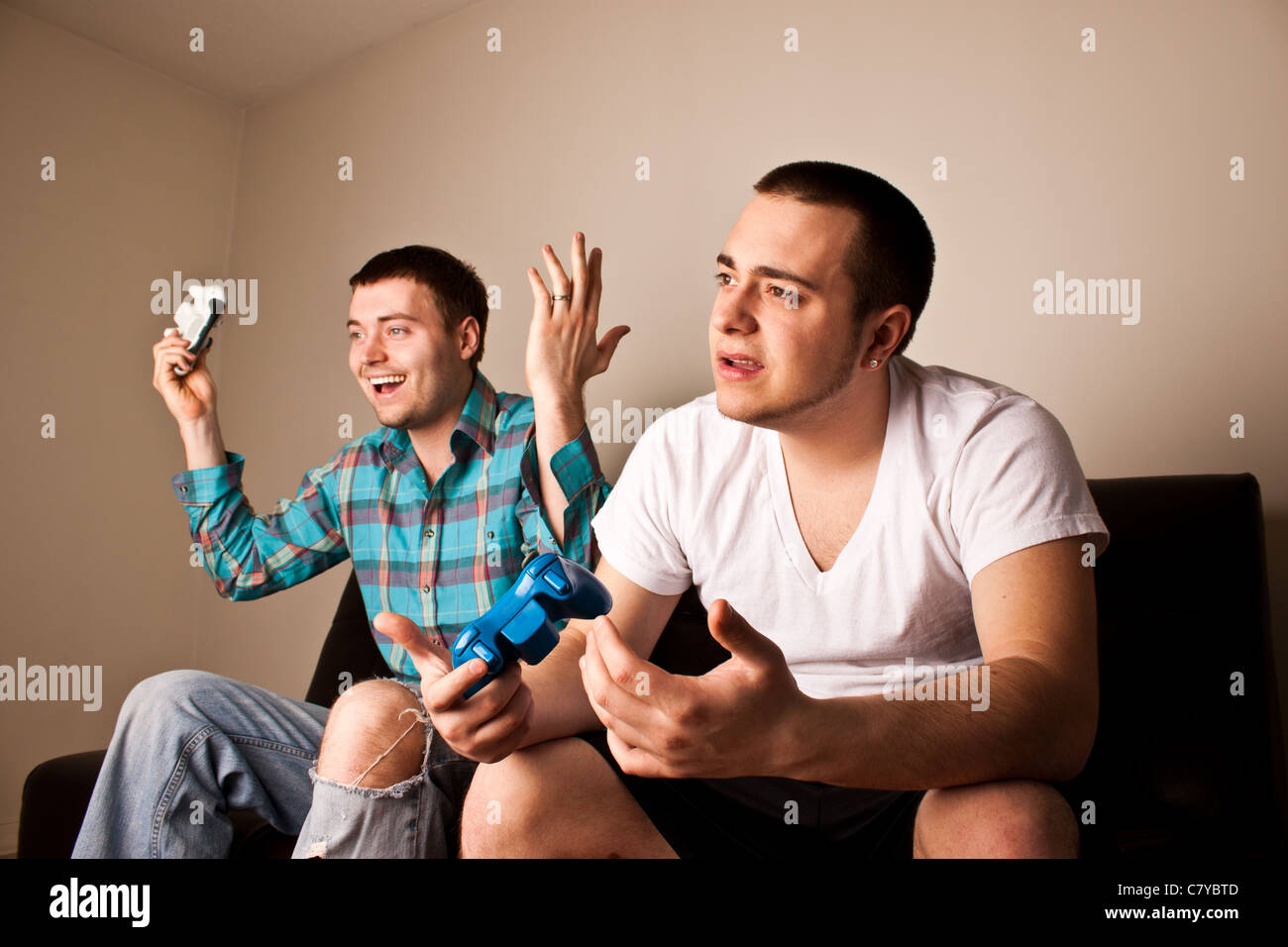 One guy loses to another while playing a video game Stock Photo