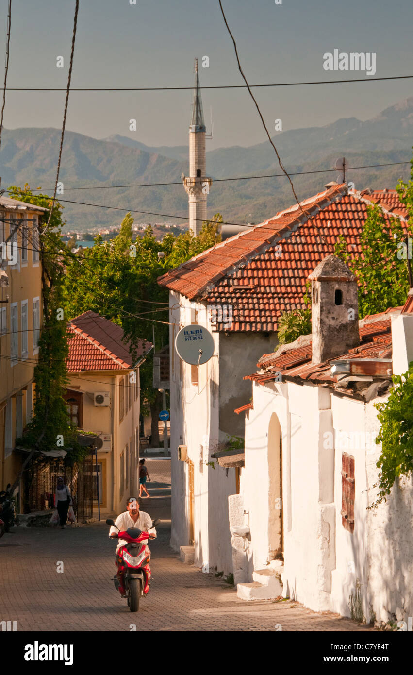 Local man on Moped Climbing a Hill in the atmospheric backstreet's of Fethiye, Turkey, Europe Stock Photo