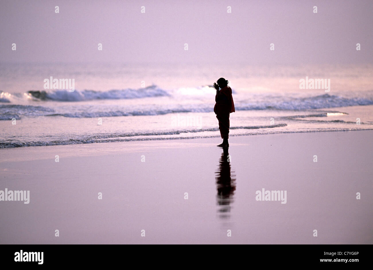 Pregnant woman on beach at sunset Stock Photo