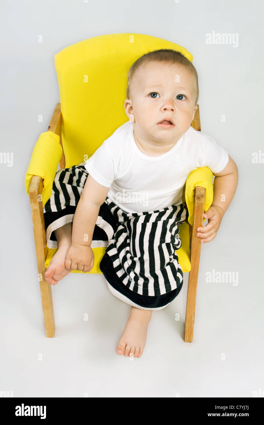 Little boy sitting on chair in striped pants Stock Photo Alamy