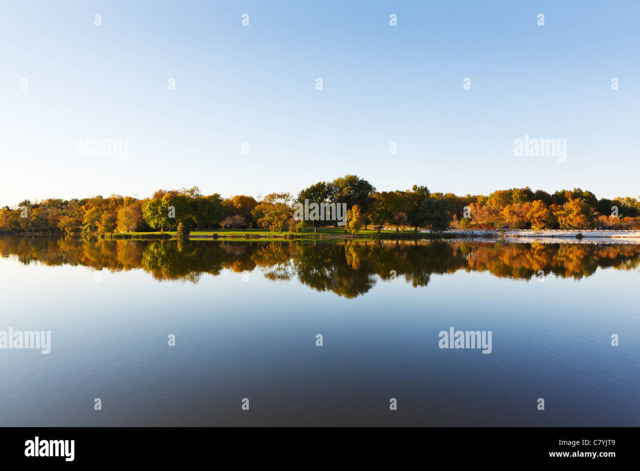 Trees with fall colors reflected in a lake Stock Photo - Alamy