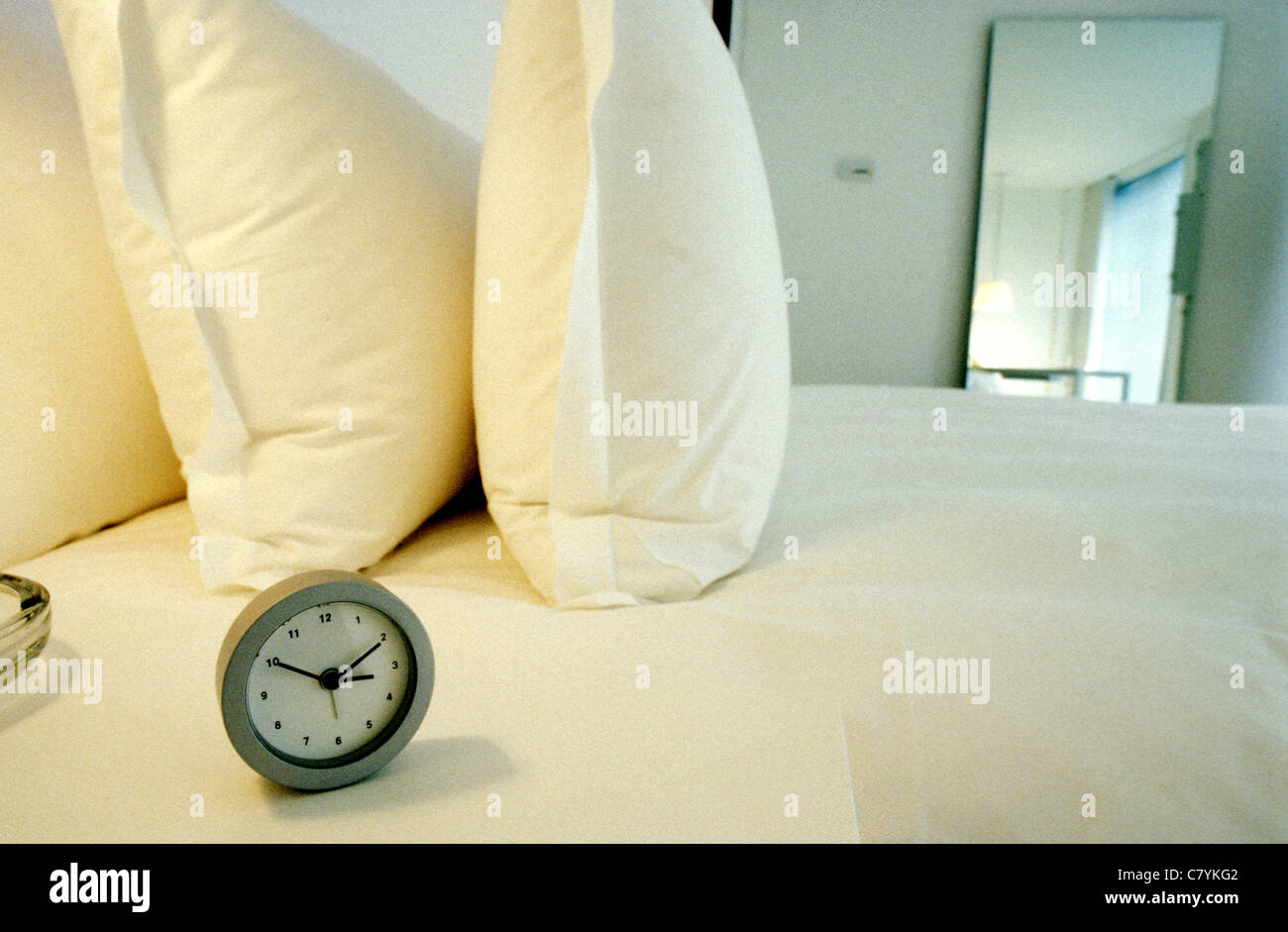 Alarm clock on bed Stock Photo Alamy
