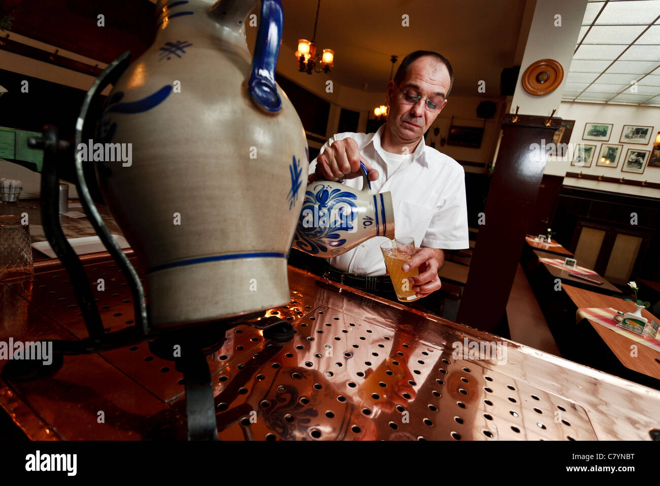 Barman serving a famous type of german cider called Apfelwein, a local speciality of Frankfurt. Stock Photo