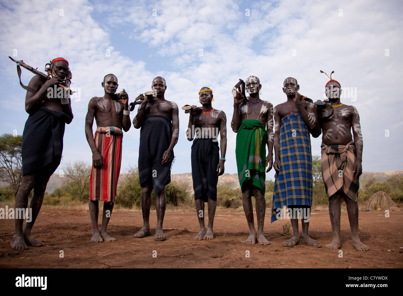 Mursi warriors standing in traditional dress with AK47 guns, Jinka, Omo Valley, Ethiopia, Africa Stock Photo