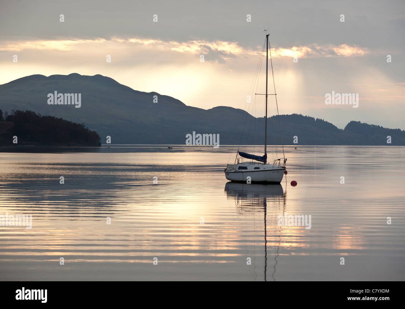 A sailing yacht moored in Loch Lomond, Scotland as the sun rises Stock