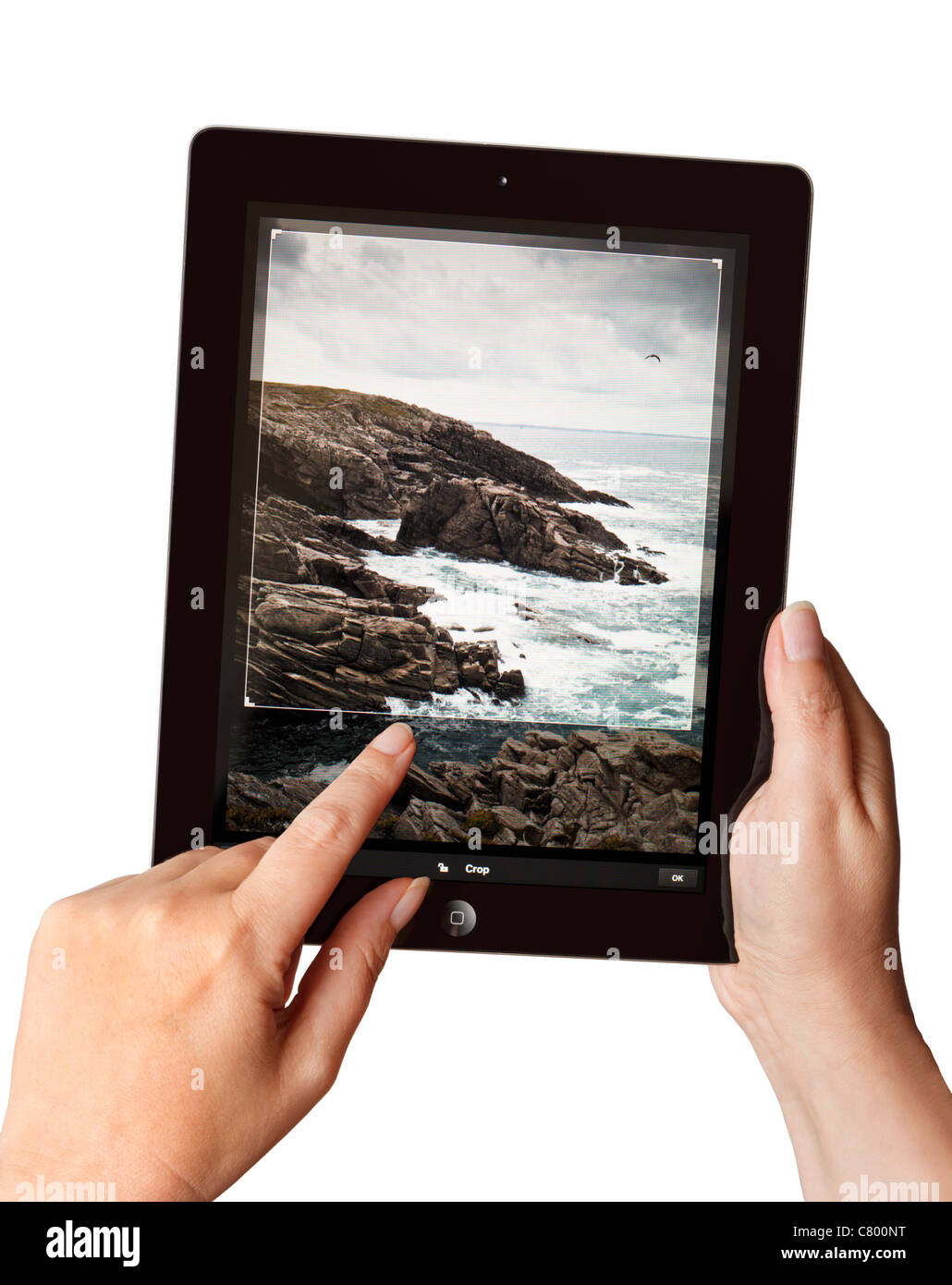 Hands holding a 2011 iPad2 using a Photoshop app to edit a photo Stock Photo