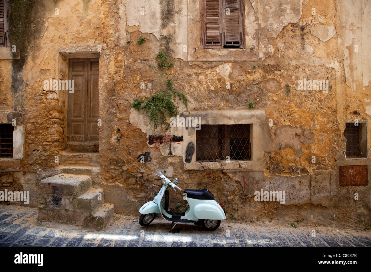 Old Vespa 50 scooter parked on the street in Caltagirone (Sicily, Italy). Vintage Piaggio moped motorcycle near old building wall in Sicilia, Italia Stock Photo