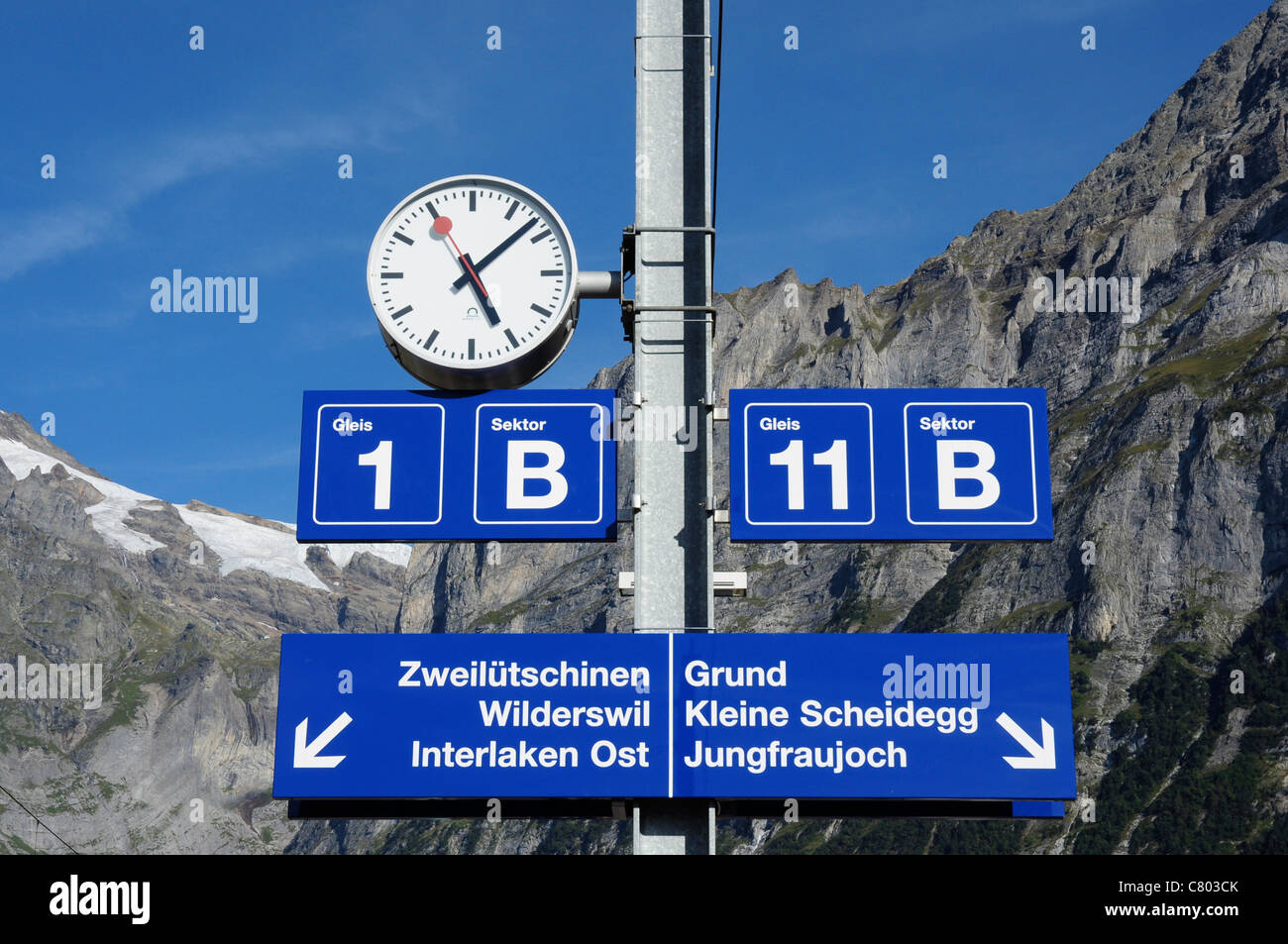 Swiss railway station clock and platform signs, Grindelwald, Bernese Oberland, Switzerland Stock Photo