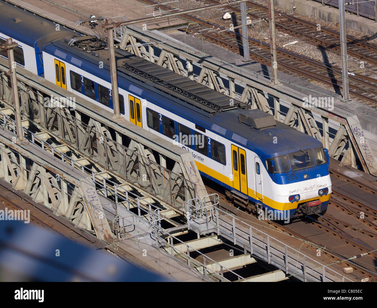 Dutch NS 'sprinter' commuter train crossing a bridge in Amsterdam, the Netherlands Stock Photo