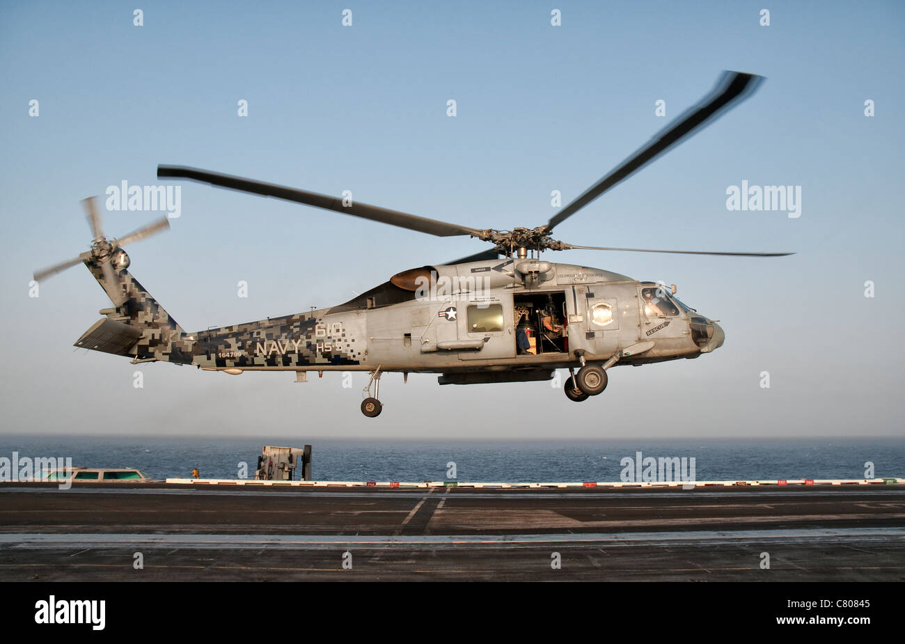 A US Navy SH-60F Seahawk hovers above the flight deck of USS Eisenhower. Stock Photo