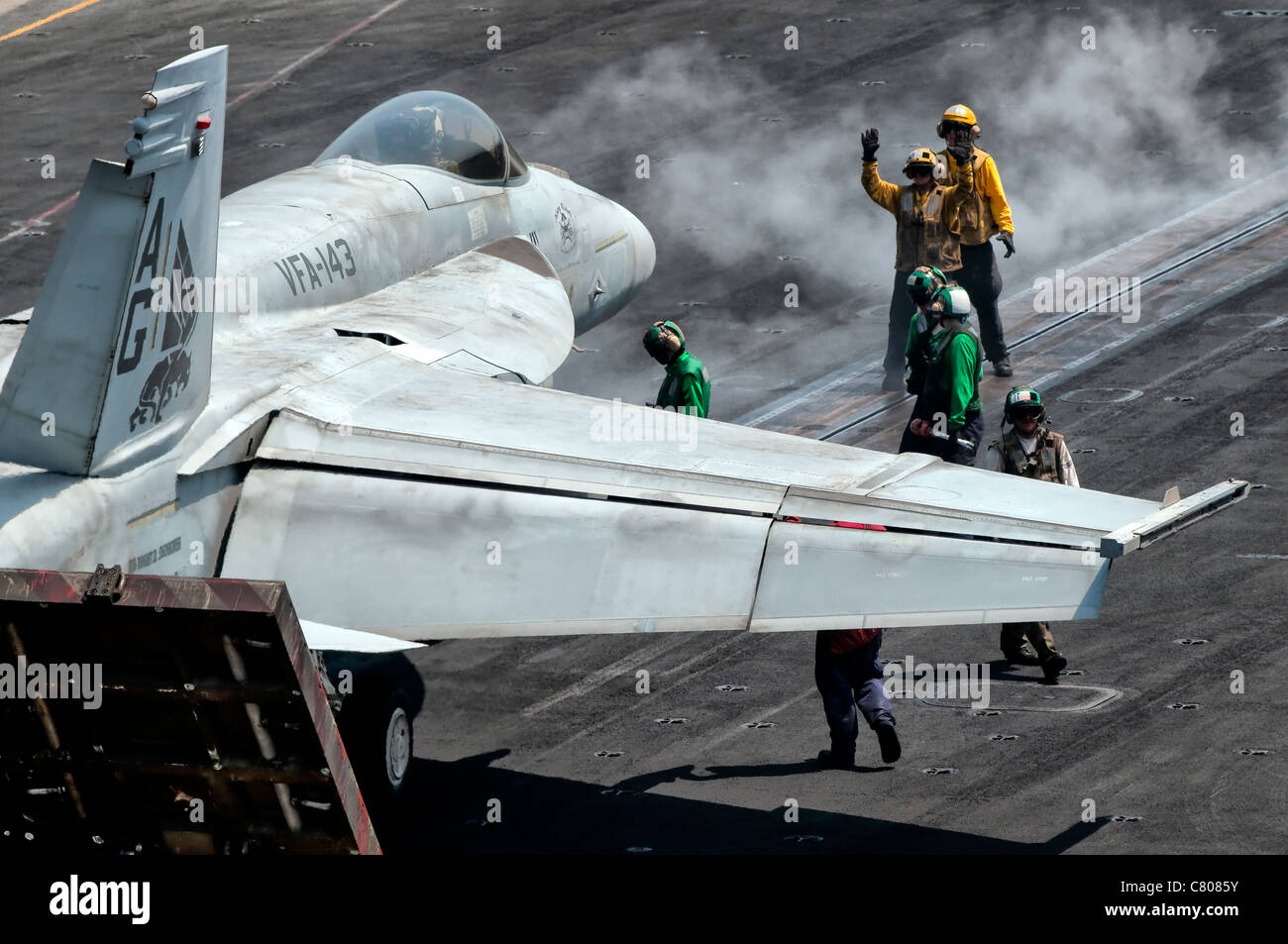 Flight deck crew position an F/A-18E Super Hornet into launch position aboard USS Eisenhower. Stock Photo