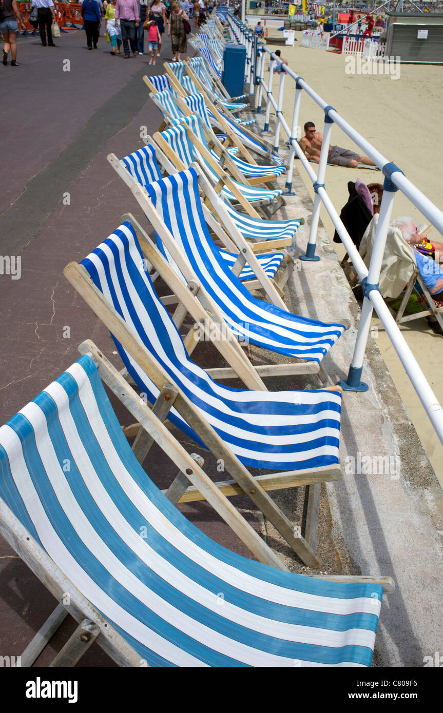 Row of deck chairs on the promenade by Weymouth beach, Devon. Stock Photo