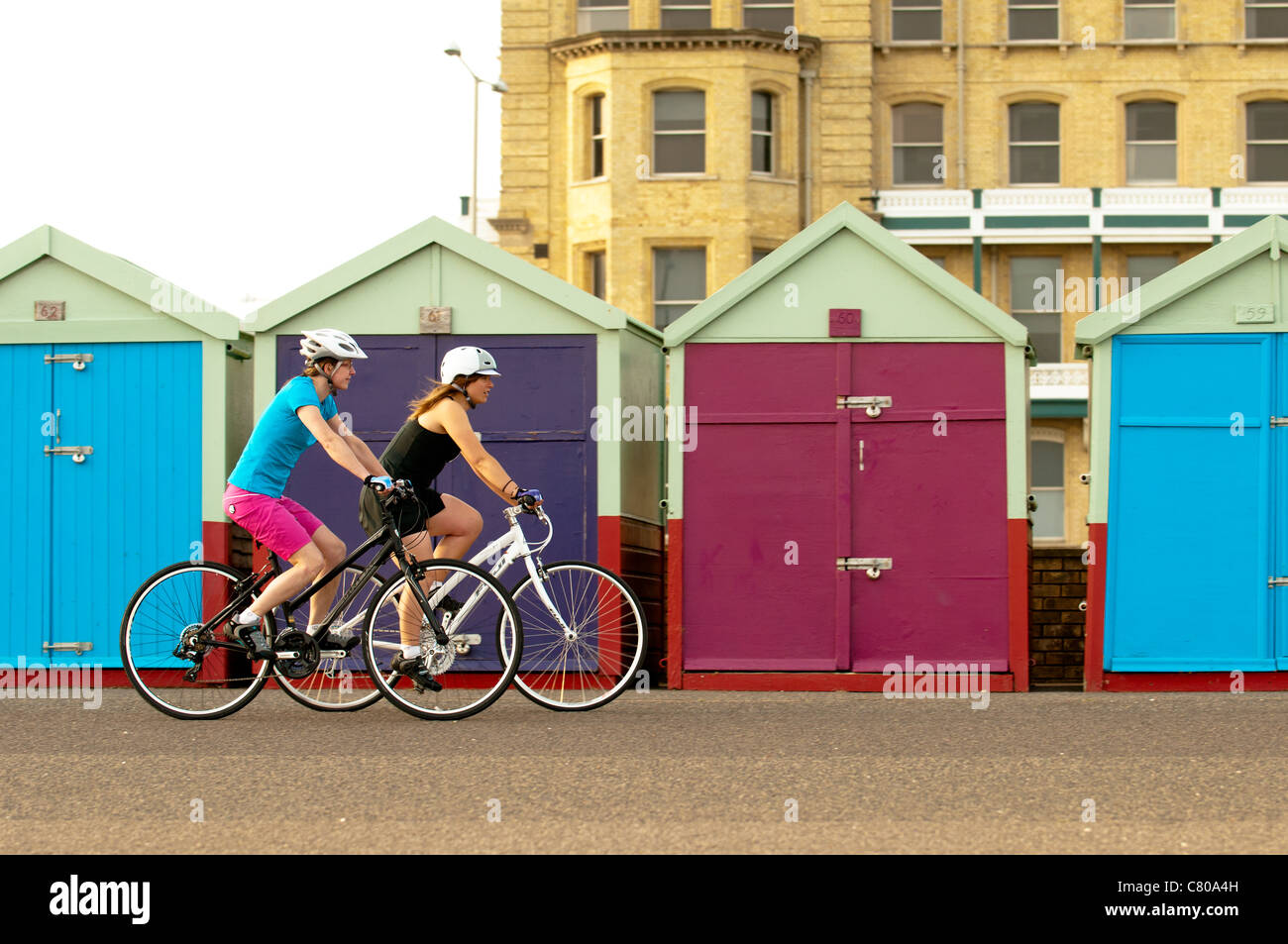Women cycling on the sea front at Brighton, England. Stock Photo