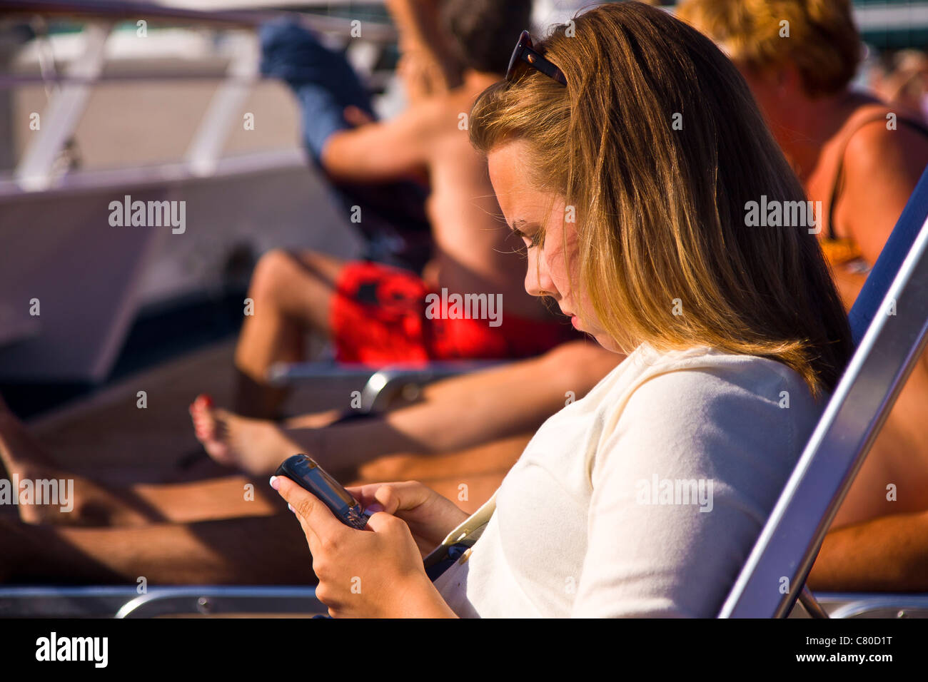 Teenage girl texting while on cruise ship Stock Photo