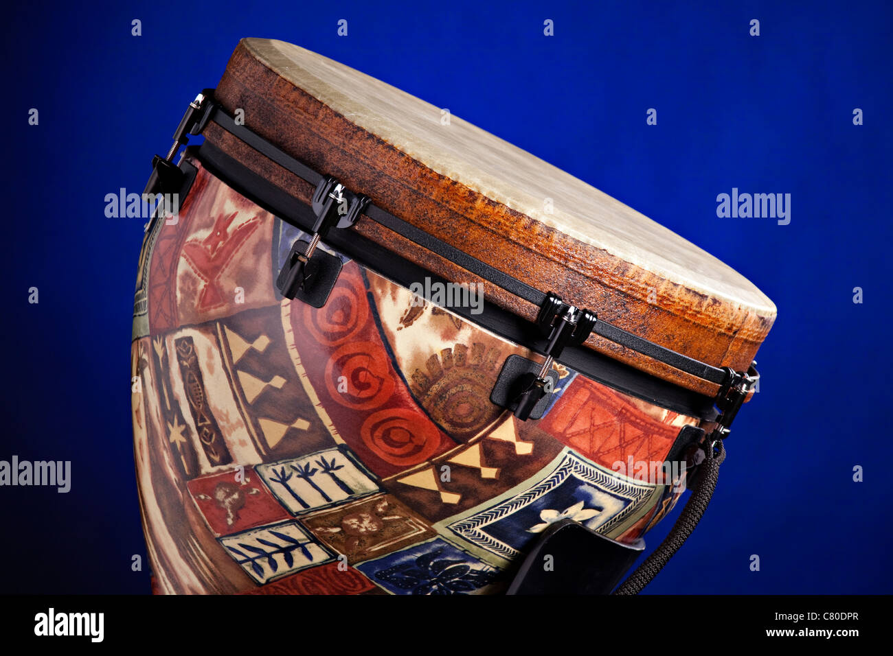 An African or Latin djembe drum isolated against a spotlight blue