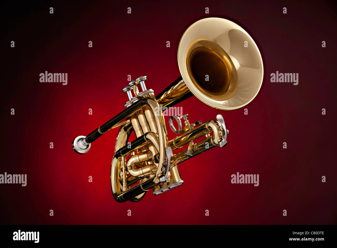 A gold brass or trumpet isolated against a spotlight red