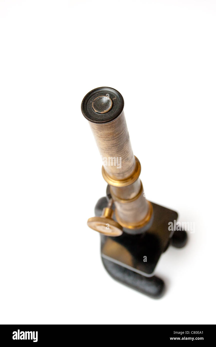 An antique monocular microscope cut out.  Focus is on eye piece with rest out of focus. Stock Photo