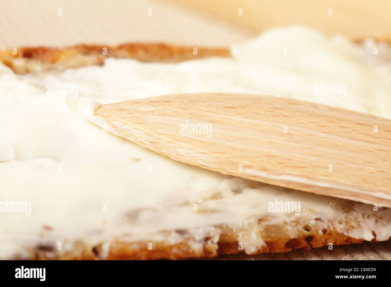 bread slices butter on a board with a wooden knife Stock Photo