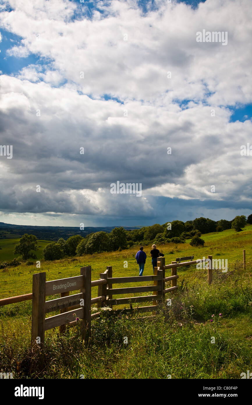People walking on Brading Downs with an approaching rain shower, Isle of Wight, England Stock Photo