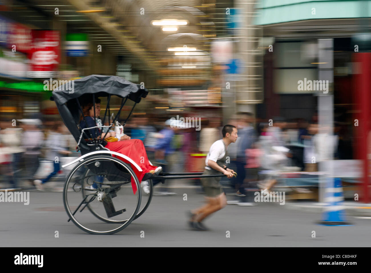Japan, Asakusa, rickshaw driver running and pulling rickshaw Stock Photo